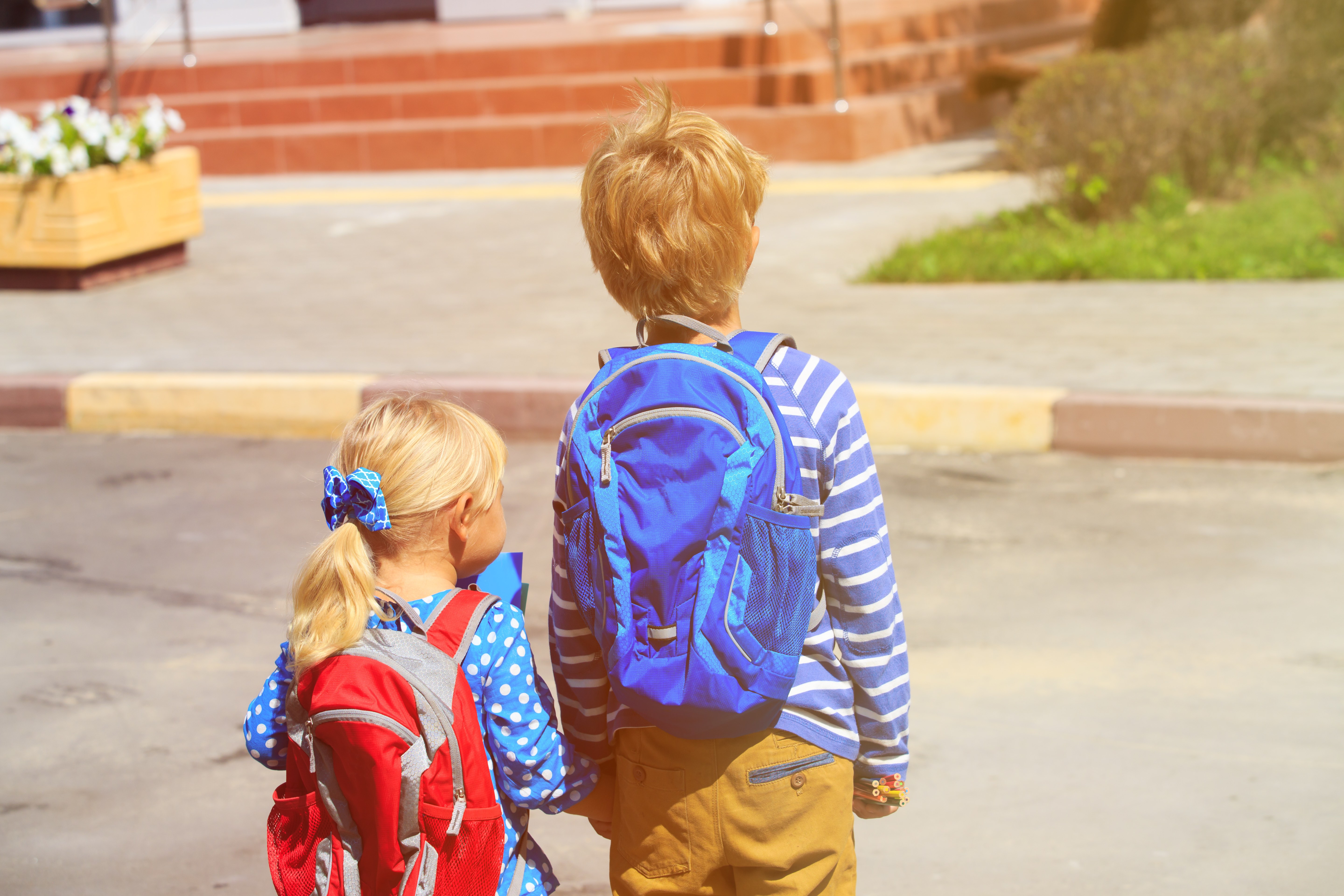 young child goes to school with brother