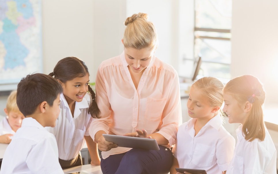 Teacher teaching kids on digital tablet