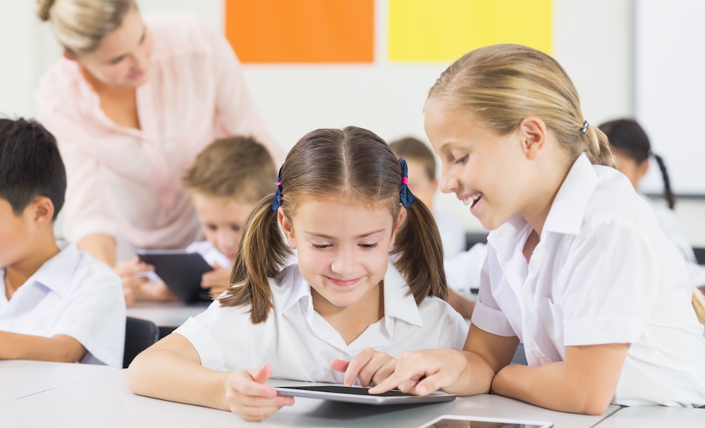 School kids using digital tablet in classroom