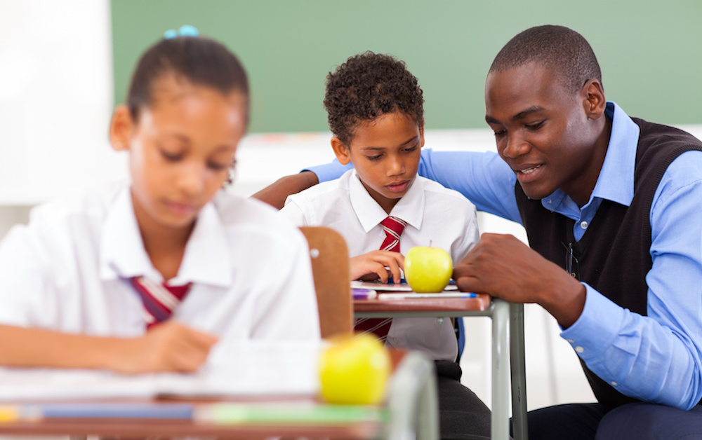 primary school teacher helping student