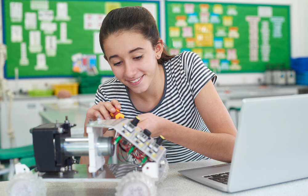 Female Pupil In Science Lesson Studying Robotics