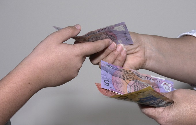 Hands of children exchanging five dollar notes