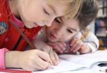 Young school children writing in a book