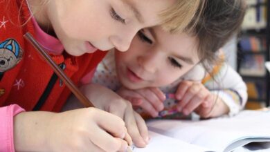 Young school children writing in a book