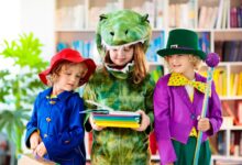 Three young children wearing costumes looking at books
