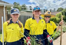 three students gardening