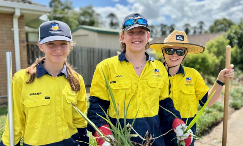 three students gardening