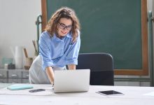 Smiling teacher with laptop