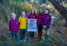 Students holding sign, reading Save our Rivers