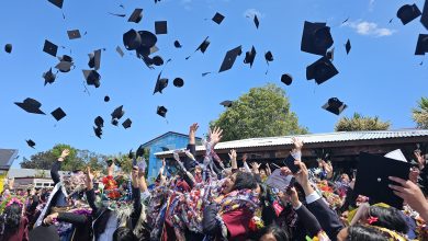 Graduating students throw hats in the air